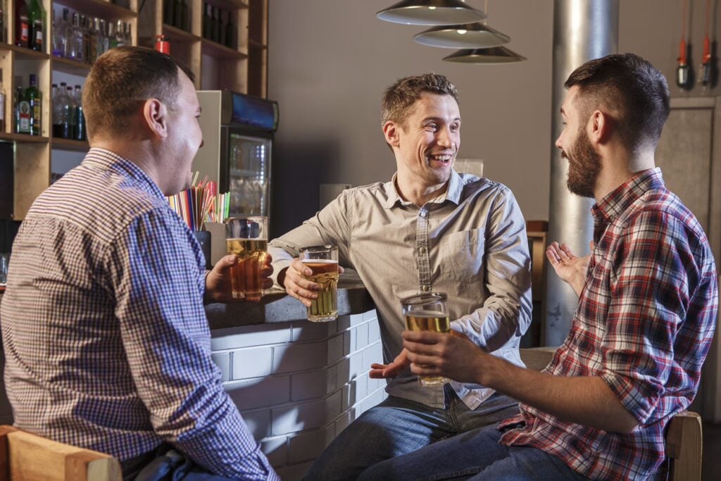 Drinking In Singapore: Your Guide To A Stress-Free Night Out 2 Happy Smiling Friends Drinking Beer Pub 1