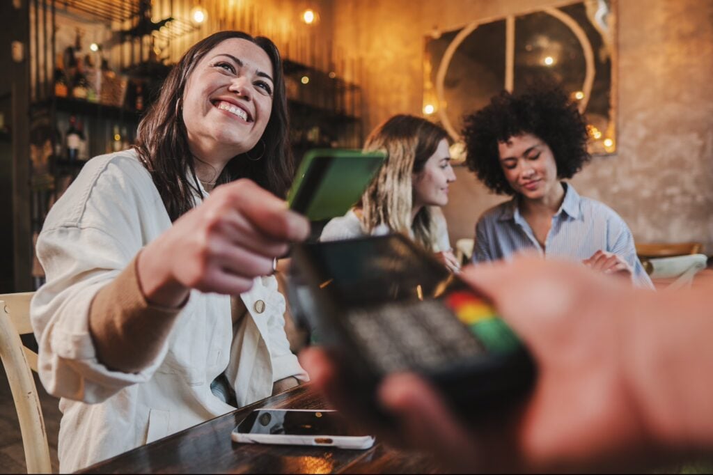 Happy Young Woman Paying Bill